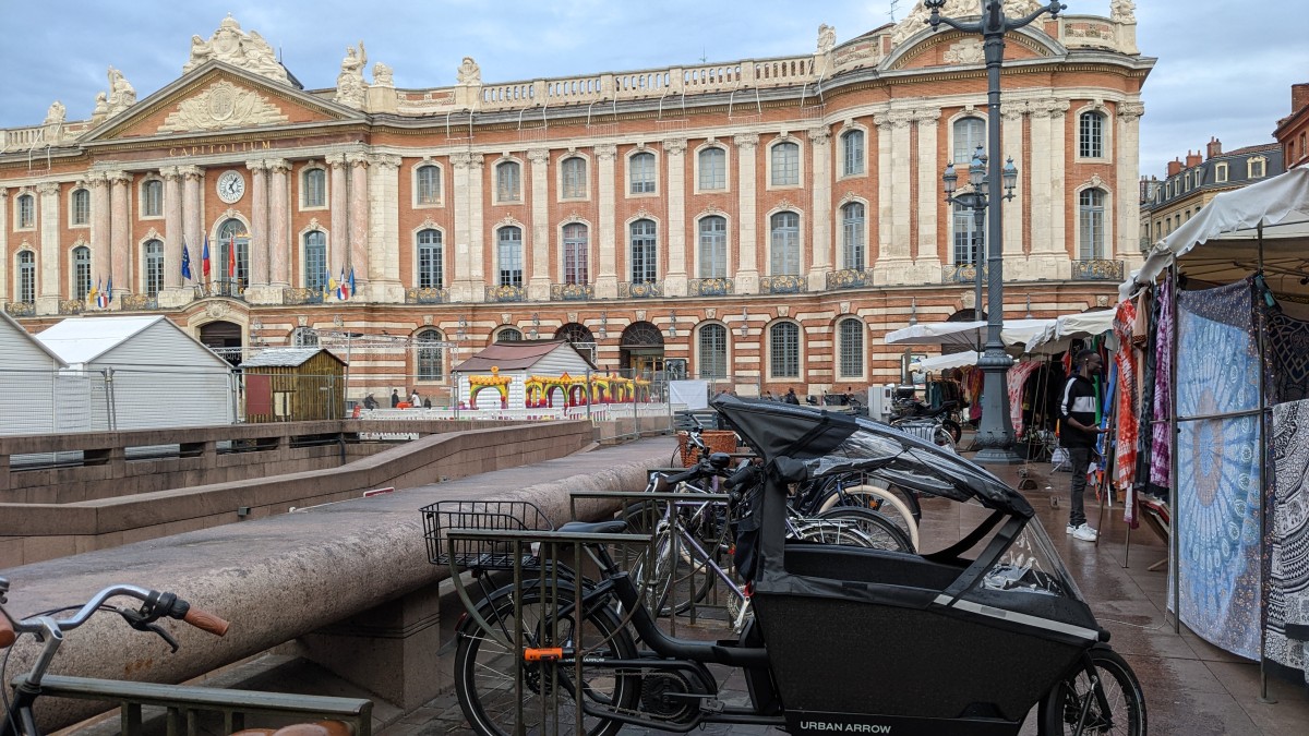 Bikes locked in front of the Capitole in Toulouse. The buildings are all for the Christmas market that was about to begin.