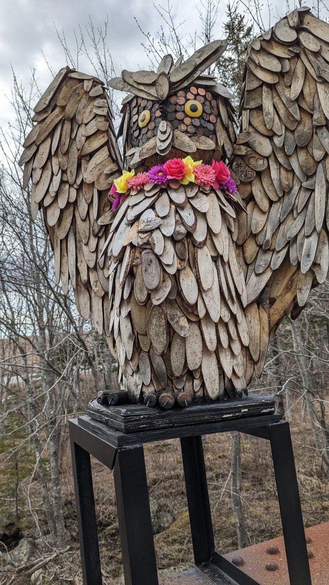 Wooden sculpture of an owl wearing a lei
