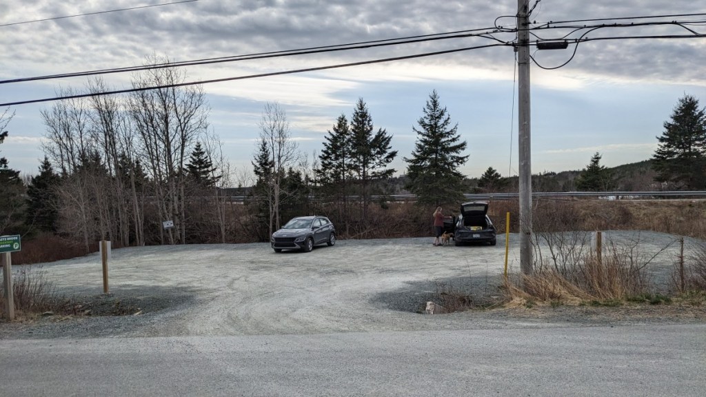 Large gravel parking lot with two vehicles.
