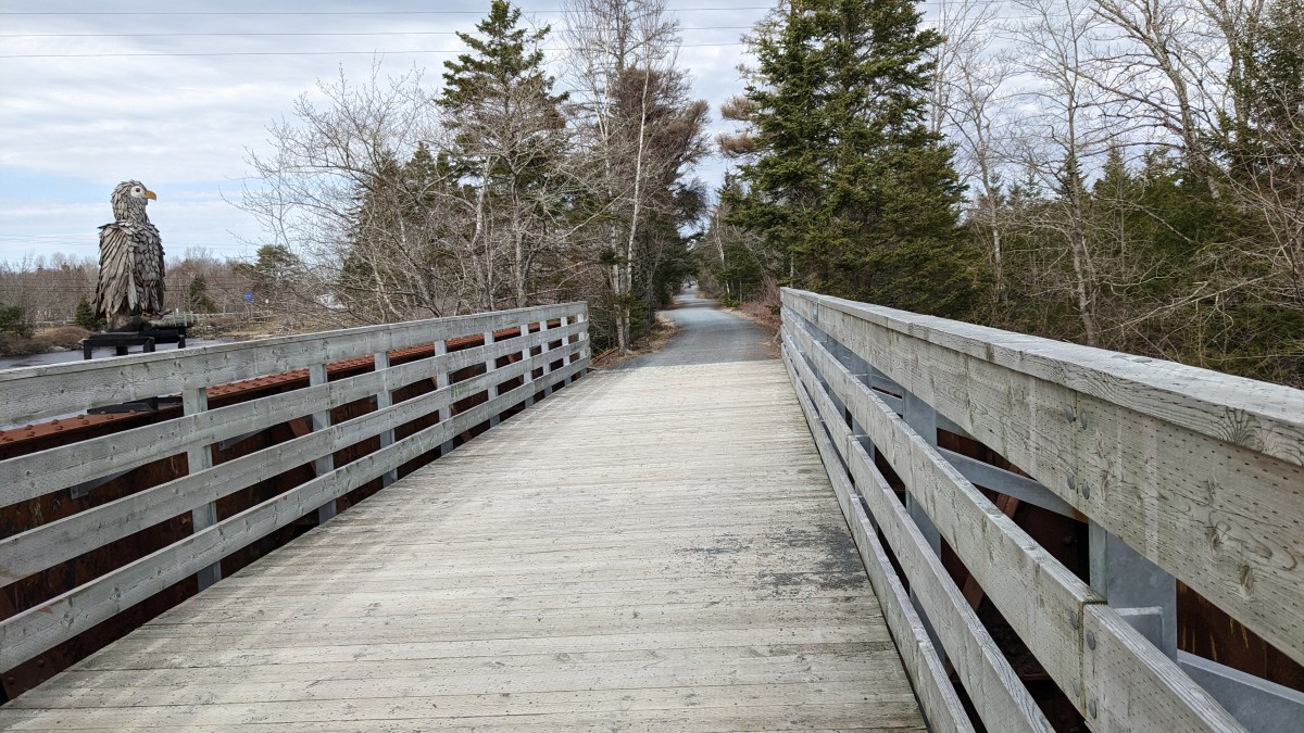 Wooden bridge with a sculpture of a bird on one side